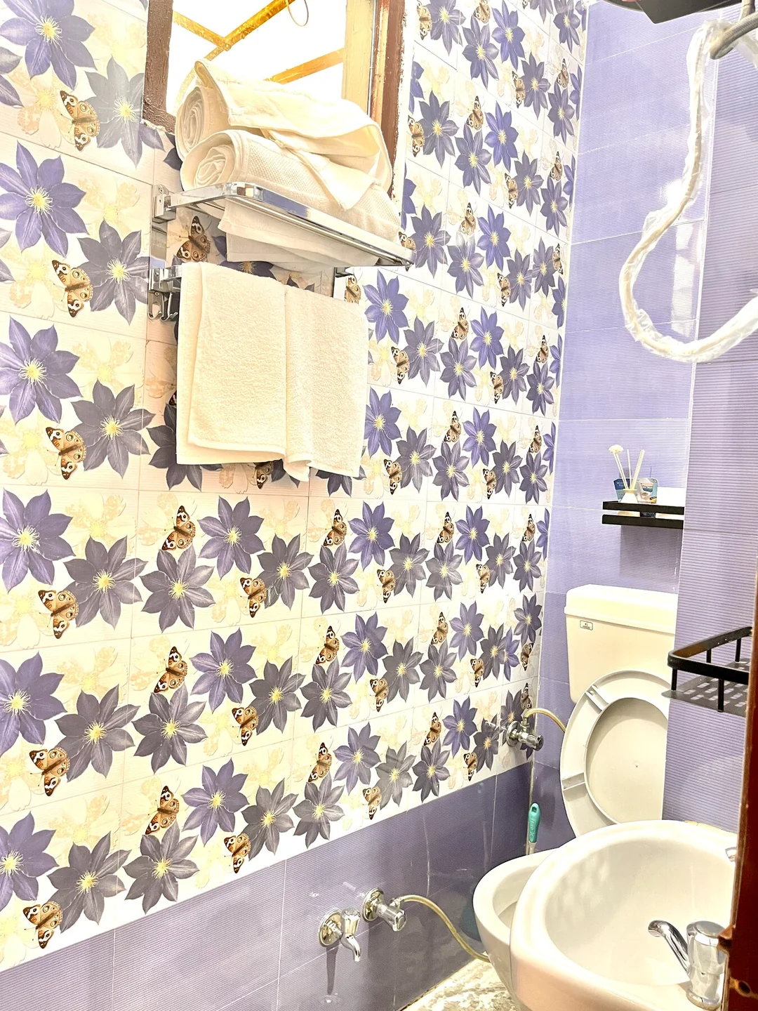 Floral-accented bathroom with hot water and toiletries